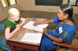 A scribe (secondary grade teacher) writing Plus Two examination for a visually-challenged student at a school.